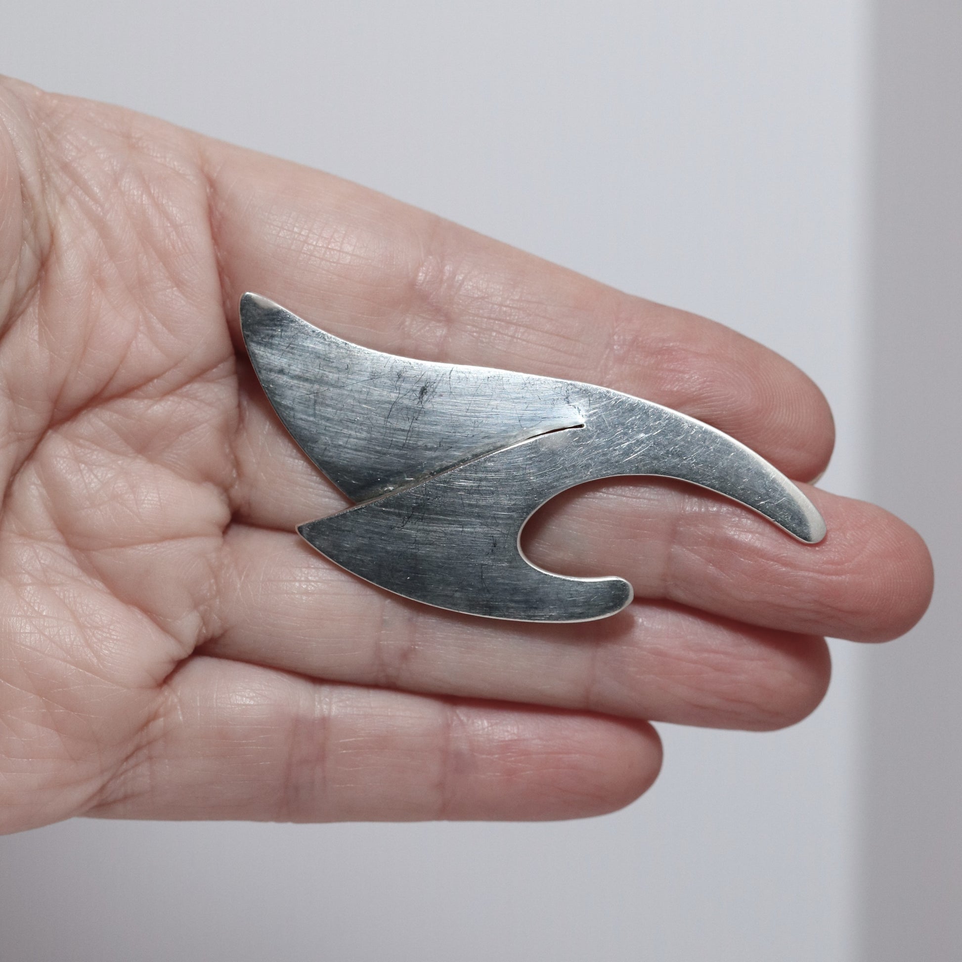 Sigi Pineda abstract sterling silver brooch from Taxco, Mexico, held in hand