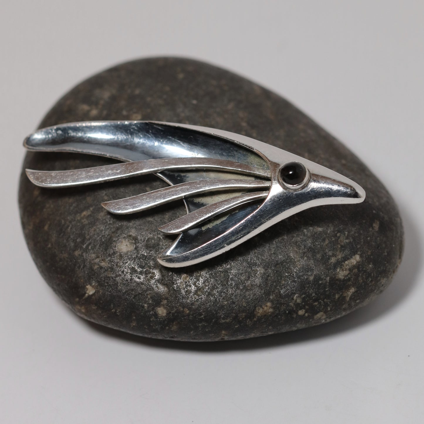Sigi Pineda abstract silver fish or bird brooch on stone background