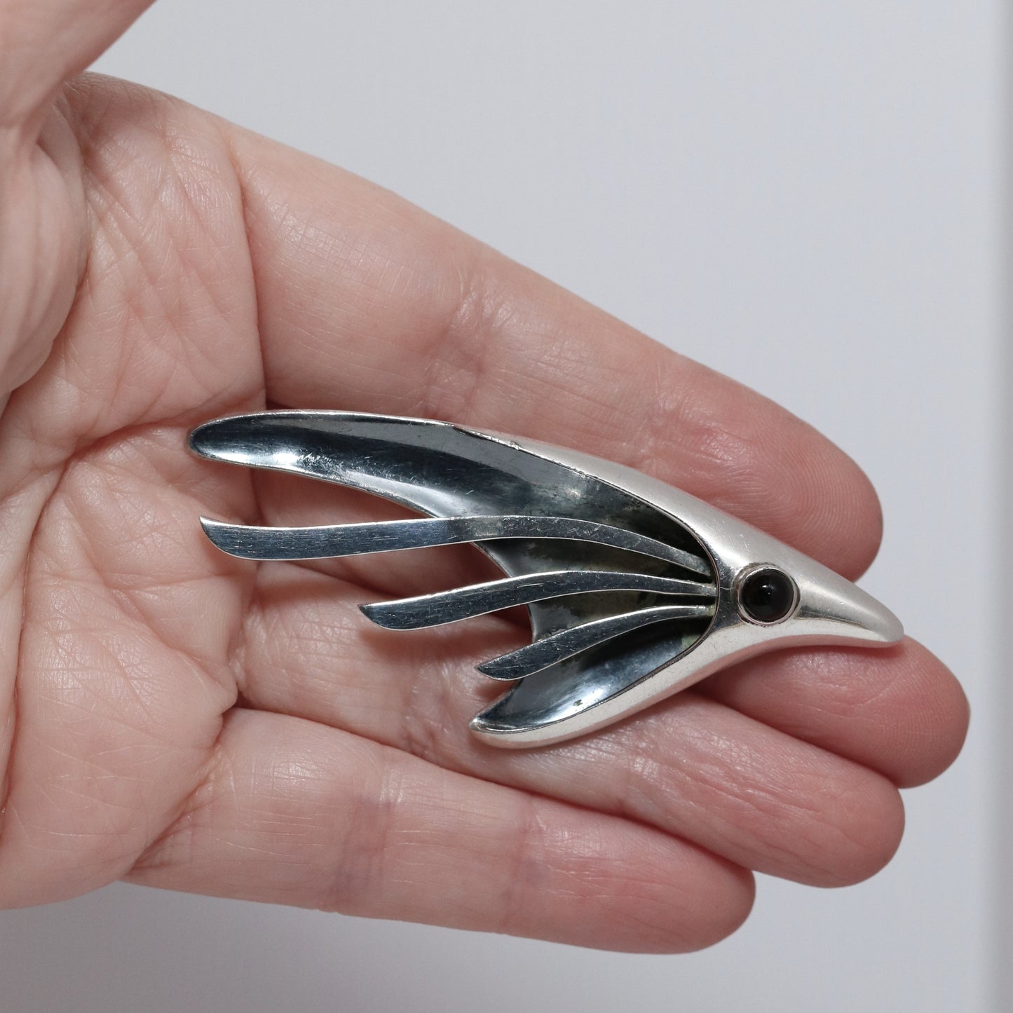 Sigi Pineda abstract silver fish or bird brooch in hand, vintage Taxco jewelry