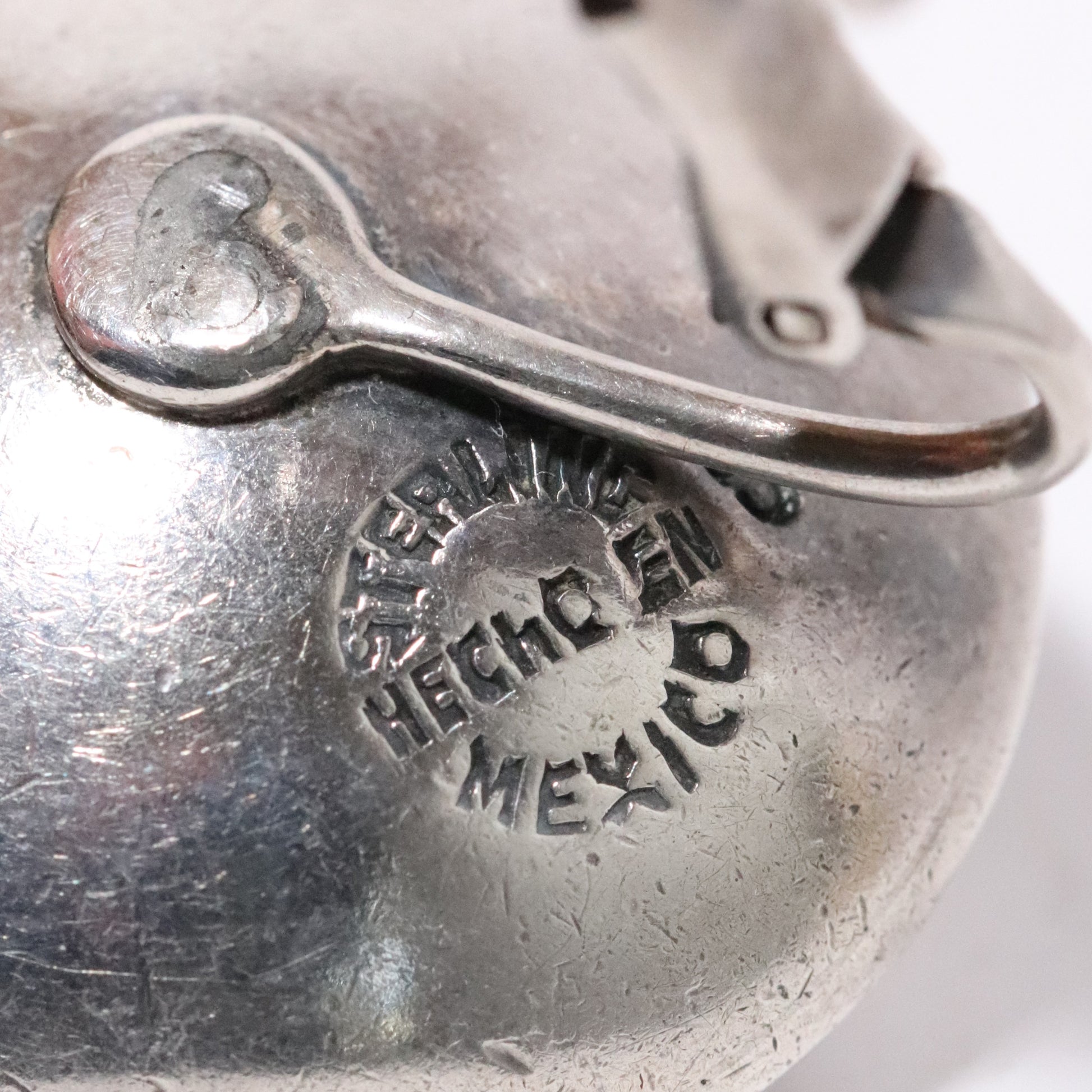 Sigi Pineda Taxco sterling silver earrings with encased ball detail, close-up of hallmark.