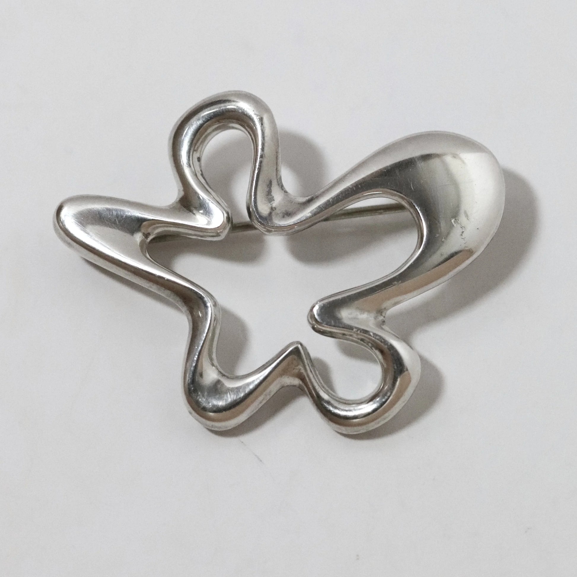 Henning Koppel abstract silver brooch by Georg Jensen, vintage designer jewelry on white