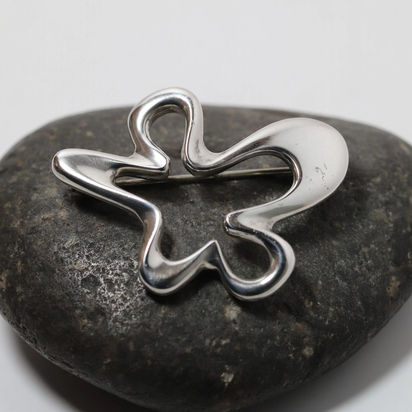 Henning Koppel abstract silver brooch by Georg Jensen on dark stone