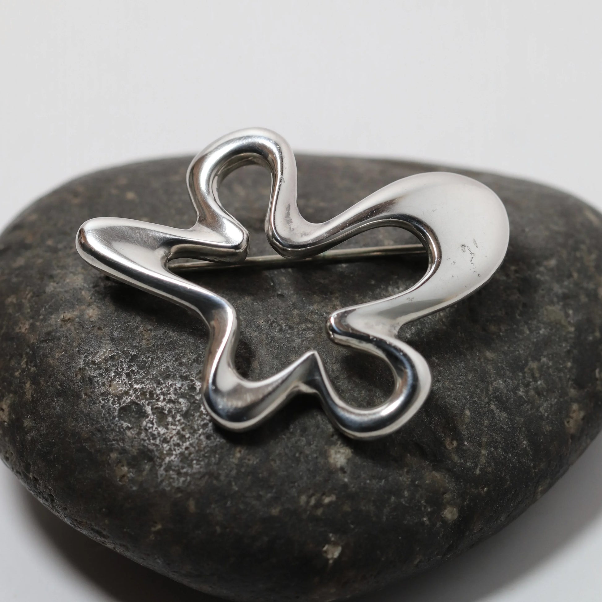 Henning Koppel abstract silver brooch by Georg Jensen on dark stone