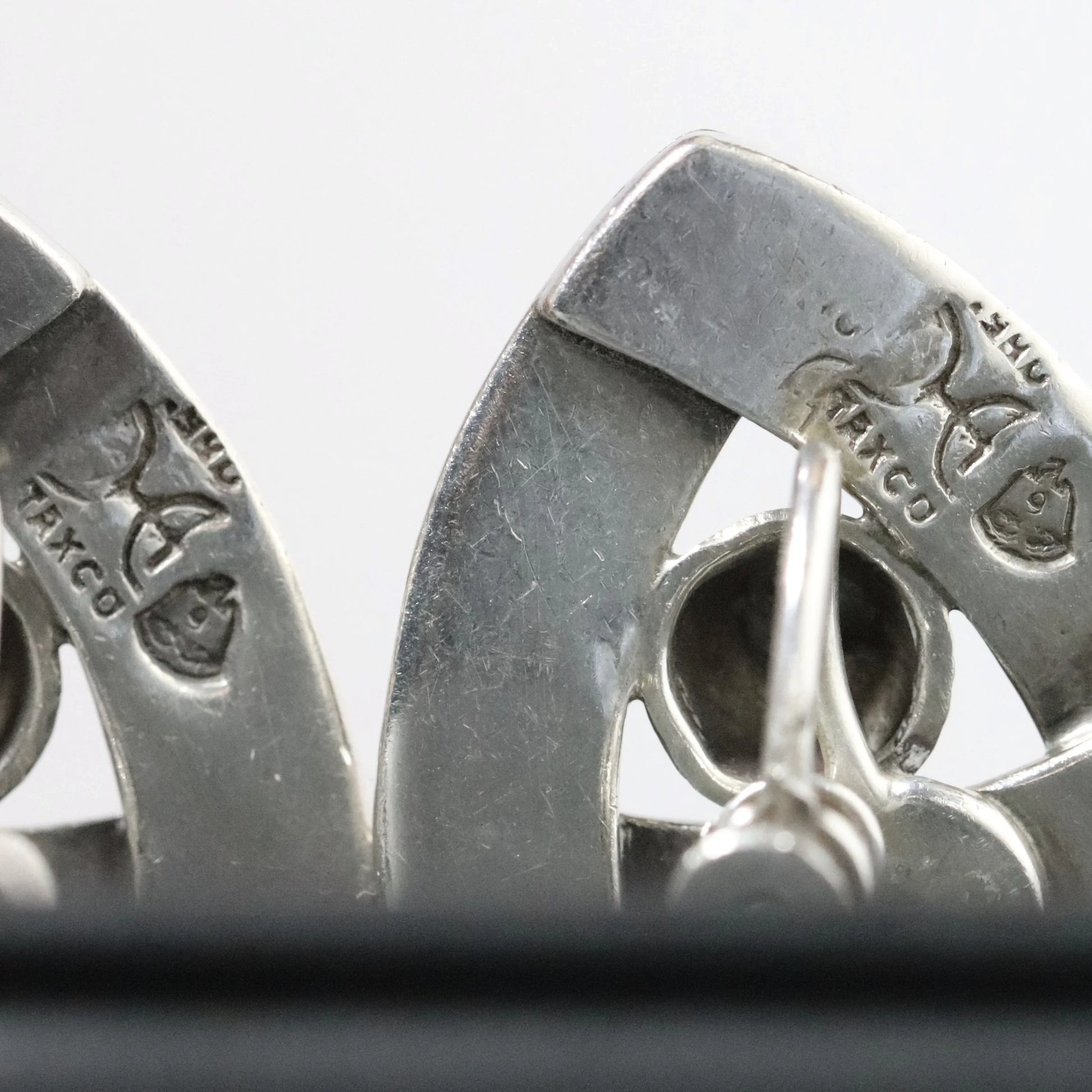 Close-up of stamped silver Mexican Taxco jewelry with hallmark and clasp visible